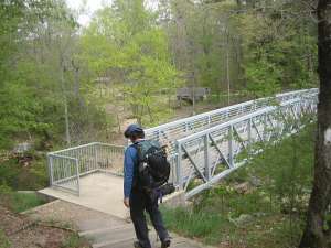Hiker preparing to cross the bridge over the Little Missouri River near the falls.
